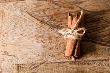 Wall Mural - Cinnamon sticks dried tree bark spice on rustic wooden table background. Selective focus.