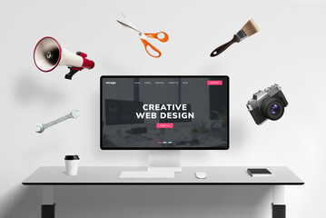 Fototapete - Web design studio page on display with flying concept web tools: megaphone, scissors, brush, photo camera, wrench key. Creative digital workspace visualized