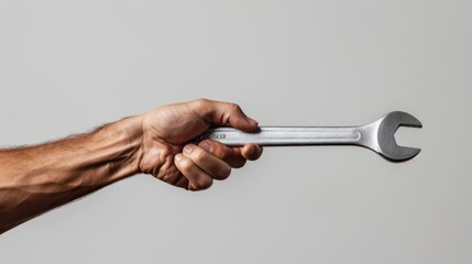 minimalist close-up of a mechanic's hand holding a wrench against a plain background