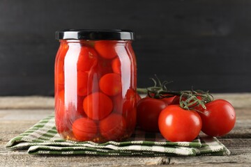 Wall Mural - Tasty pickled tomatoes in jar and fresh vegetables on wooden table