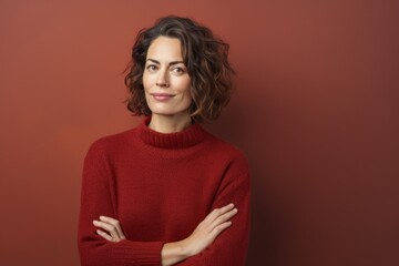 Wall Mural - Portrait of a content woman in her 40s dressed in a warm wool sweater isolated on blank studio backdrop