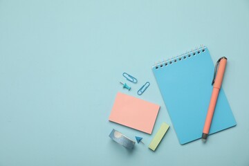 Wall Mural - Flat lay composition with notebook and different stationery on light blue background, space for text