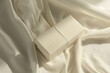 © Krisartist94 - Simple white gift box on smooth fabric in soft light