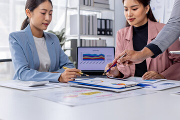 Wall Mural - Group of casually dressed asian businesspeople discussing ideas in the office. Creative professionals gathered at the meeting table for discuss important issues of the new successful startup project	