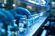 © yulei ning - Medicine, vaccine concept, a hand wearing medical gloves is operating drugs on the assembly line