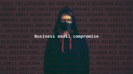 Cyber attack business email compromise text in foreground screen, anonymous hacker hidden with hoodie in the blurred background. Vulnerability text in binary system code on editor program.