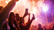 © XaMaps - Group of friends taking a selfie together in front of the main stage at a rock concert with bright lights and pyrotechnics.