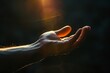 © CreativeArts - powerful sunlight falls on the hand in a dark background, seeking help concept