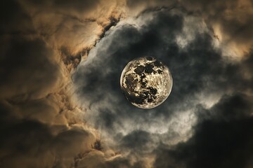 Wall Mural - A full moon visible through a break in storm clouds after a rainstorm