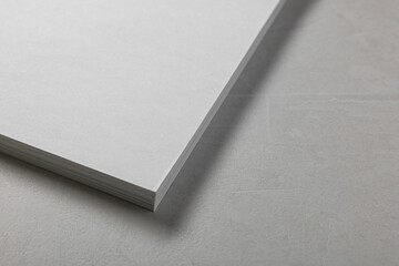 Wall Mural - Blank paper sheets on grey textured table, closeup. Mockup for design