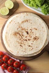 Canvas Print - Many tasty homemade tortillas and products on wooden table, flat lay