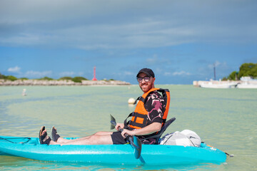 Wall Mural - tourist with paddle in a sea blue kayak in a tropical bay 