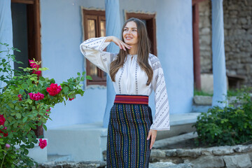 Wall Mural - Beautiful traditional costume from Republic of Moldova. Young girl wearing Romanian traditional blouse.