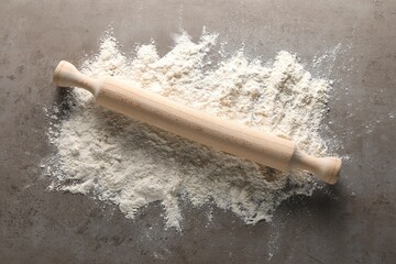 Wall Mural - Scattered flour and rolling pin on grey textured table, top view
