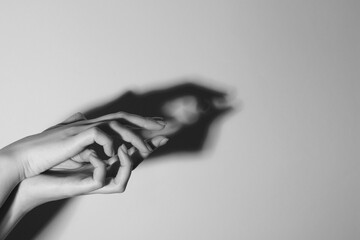 Wall Mural - Shadow puppet. Woman making hand gesture like crocodile on light background, closeup with space for text. Black and white effect