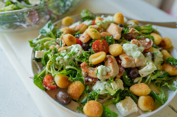 Wall Mural - Delicious summer salad with chicken meat, vegetables, feta cheese, gnocchi and dressing