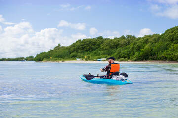 Canvas Print - tourist with paddle in a sea blue kayak in a tropical bay 