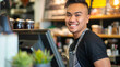 © Michael - Cheerful male barista smiling in front of espresso machine at modern café
