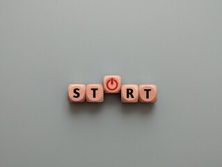 To make a new start in life, business, education or career concept. Wooden cube with start or power button.