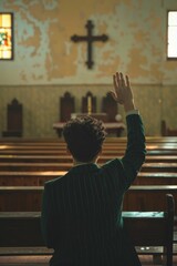 A man was sitting in a church pew, raising his arms and praying to God