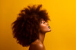 © Enrique - photo of side profile portrait of an Afro woman, seamless yellow background, high contrast