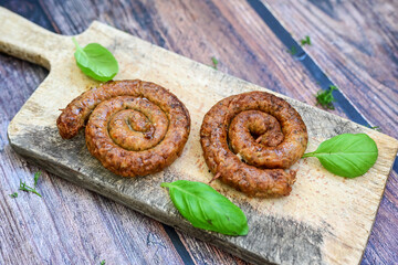 Grilled  pork  juicy sausages on wooden board outdoors. Grilling food, bbq, barbecue, picnic