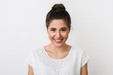 Wall Mural - close-up portrait young pretty woman smiling in white t-shirt on white background, happy, positive mood, isolated, sincere smile