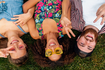 Wall Mural - happy young company of friends sitting park