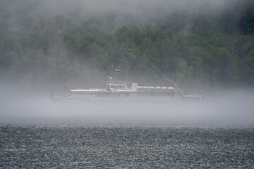 Wall Mural - thick morning fog on the lake against the backdrop of mountains landscape on Lake Teletskoye