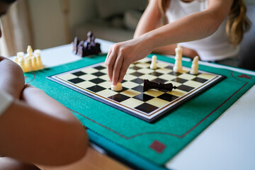 Two people playing a game of chess on a green board