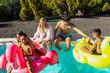 © ADDICTIVE STOCK - Triplets and siblings enjoying pool time with inflatables