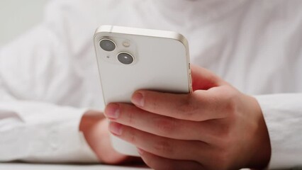 Young woman is staring and typing at phone in office workplace. Work office place concept, monitor with chroma key green screen. Communicating and chatting with smartphone.