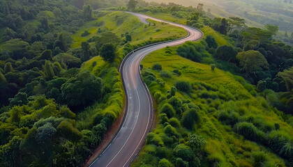 Wall Mural - Winding road, top view of beautiful aerial view of asphalt road, highway through forest and fields in rainy season