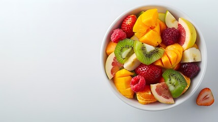 Wall Mural - Bowl of fresh mixed fruit salad on white background. Flat lay composition with copy space. Healthy eating and summer food concept for design and print