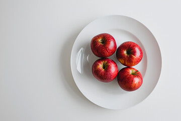 Wall Mural - Apples on a white plate on a white background
