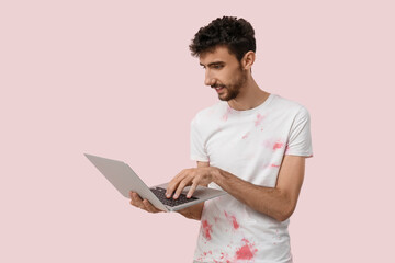 Sticker - Handsome man using laptop on pink background