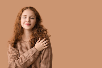 Wall Mural - Portrait of relaxed young woman on brown background