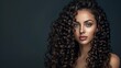 © MD Media - A beautiful woman with long curly hair posing for the camera against a dark background. This could be used as a hair salon ad banner or hair brand advertisement.