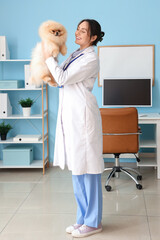 Wall Mural - Female veterinarian with cute Pomeranian dog in clinic