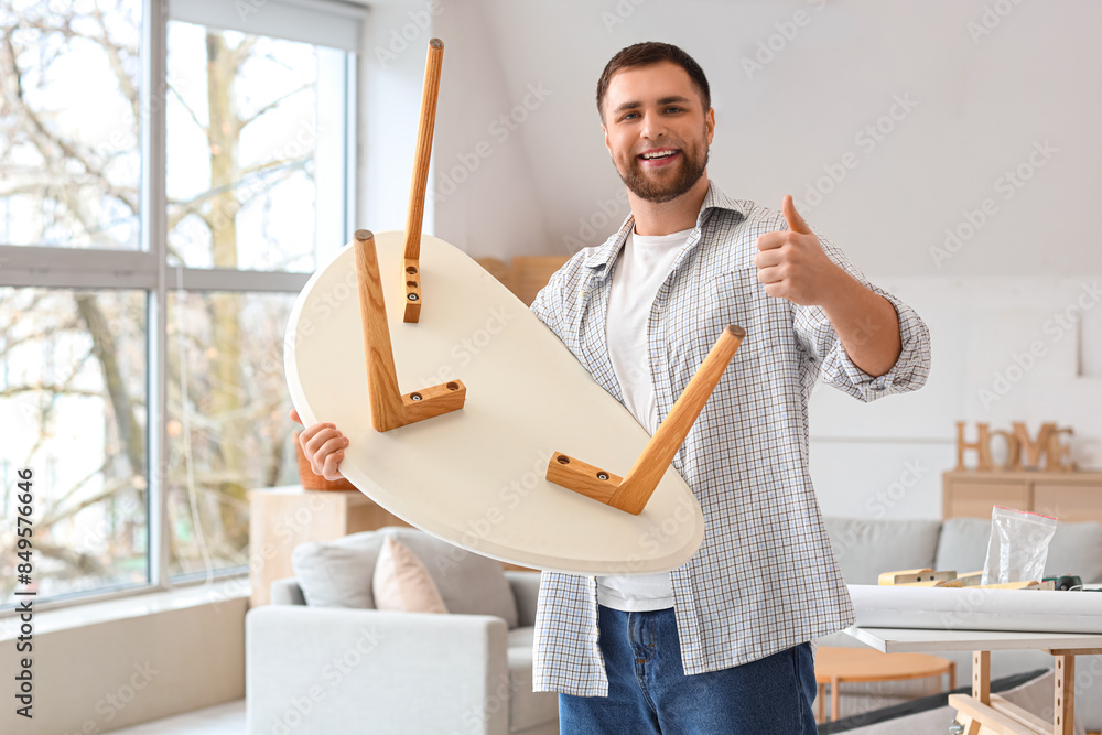 Young man with assembled coffee table at home