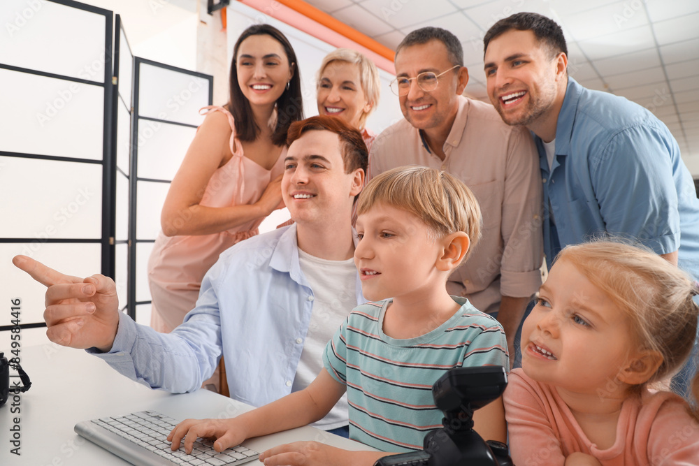 Male photographer working with big family at table in studio