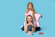 © Pixel-Shot - Cute little girl with her mom, gift boxes and bouquet for Mother's Day lying on blue background