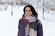 © PeterPike - Young smiling beautiful woman wearing scarf outdoors during snowfall