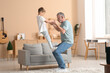 © Pixel-Shot - Grandfather with his cute little grandson having fun together at home