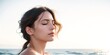 © progressman - a woman with her eyes closed standing on the beach