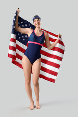 Wall Mural - Female swimmer with USA flag on light background