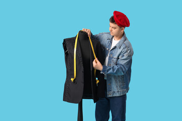 Wall Mural - Teenage fashion designer with tape measure and mannequin on blue background