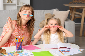 Wall Mural - Nanny and little girl with pencils having fun at home