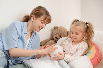 Sticker - Nanny with little girl and ball lying in bedroom