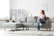 © Pixel-Shot - Young pretty woman sitting on sofa in stylish living room
